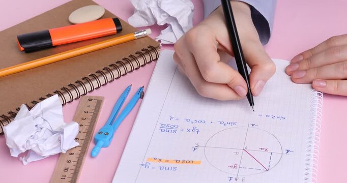 Woman doing math homework at table, closeup