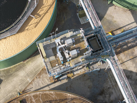 Aerial view of Brushy Creek Wastewater Treatment Plant showing industrial infrastructure, circular sedimentation tanks, metal walkways, and piping in Chirnside Park, Victoria, Australia.