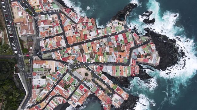 A closer aerial view reveals the narrow streets and coloured rooftops threading through Punta Brava. Architecture reads as pattern from this lower Tenerife drone altitude.