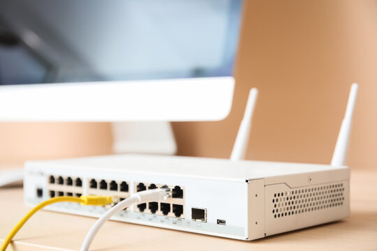 Network connectivity and internet infrastructure, ethernet switch with connected cables on office desk for business communication and data management