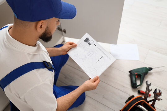 Home improvement and furniture assembly, professional handyman reading instruction manual for repair project with tools on floor in residential house