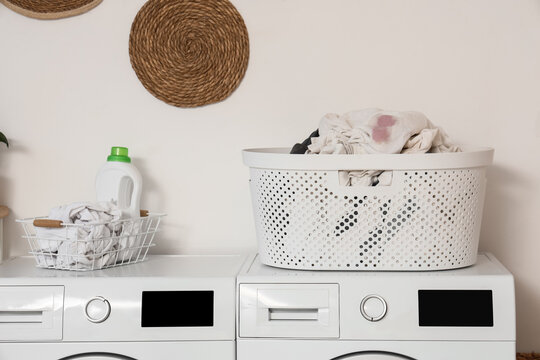 Laundry day and household chores, dirty clothes in plastic basket on washing machine with detergent bottle for home cleaning and domestic routine