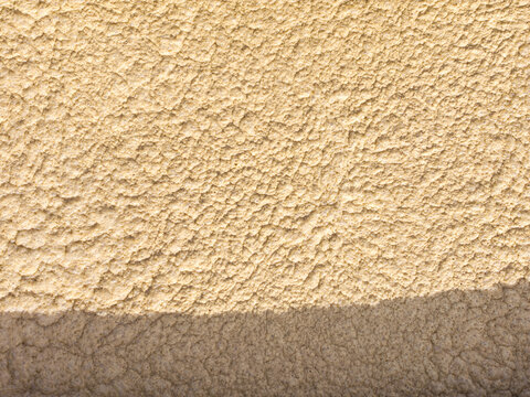 Aerial view of a textured beige wall surface with a sharp shadow line in Chirnside Park, Victoria, Australia.