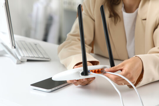 Internet connectivity and network setup, person connecting ethernet cable to wireless router for home office high speed broadband and digital access