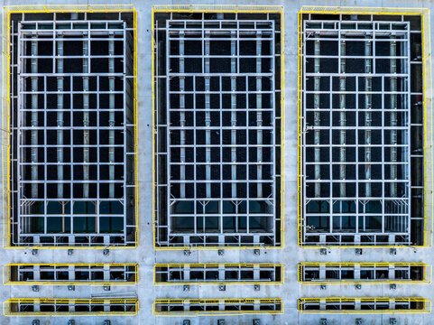 Aerial view of a modern water treatment plant featuring three large rectangular filtration basins with metal grid structures and yellow safety railings.