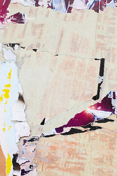 Abstract close-up of a textured paper  and torn posters with fragmented dark shapes and yellow detail