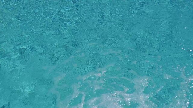 Bubbling flowing water in turquoise colored swimming pool