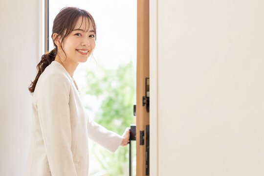ドアを開けて笑顔で振り返る女性
