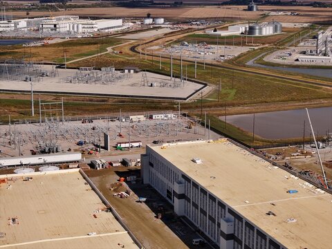 Aerial view of a large industrial facility featuring expansive flat-roofed buildings, electrical substations, and surrounding rural landscape in Washington Court House, Ohio, United States.