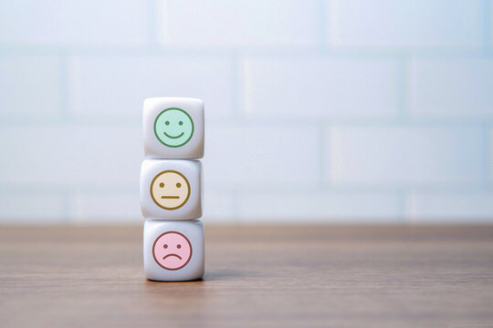Three stacked dice with happy, neutral, and sad face icons with copy space. Customer feedback, survey rating, emotional scale, evaluation, and user experience concept.