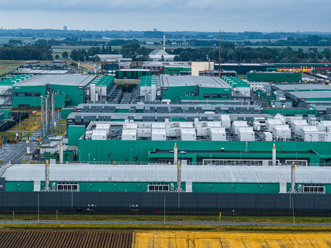 Aerial view of the Agriport A7 industrial complex featuring large green buildings with white cooling units on the roofs, surrounded by agricultural fields in Middenmeer, Noord-Holland, Netherlands.