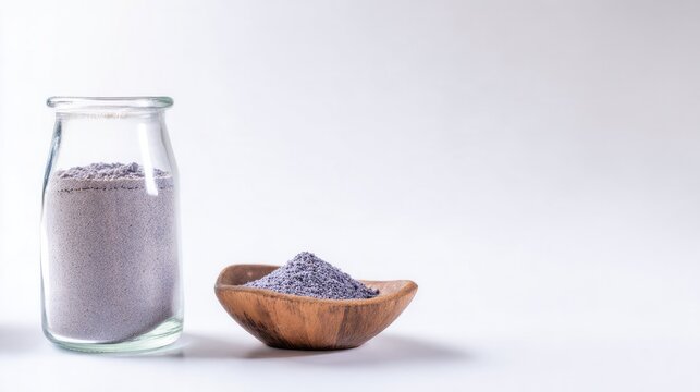 Glass jar of purple comfrey root powder with bowl, herbal remedy concept