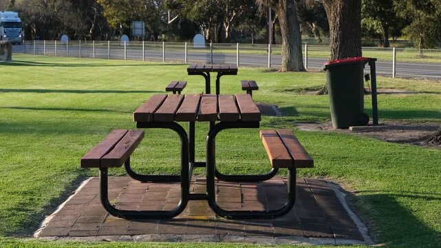 A picnic table at a roadside rest area on the Dukes Highway in Keith, South Australia.  A large truck passes in the background. Stopping point for freight transport and road trip.