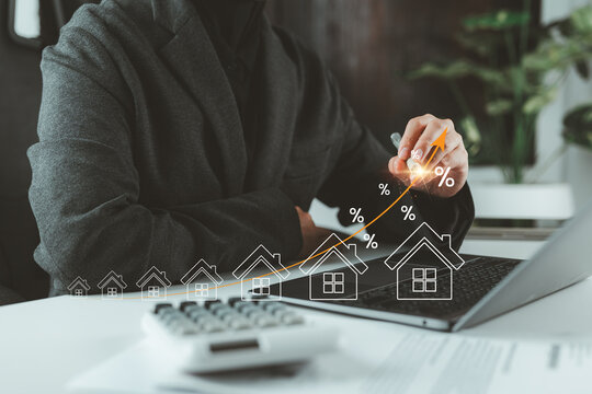 Businesswoman calculating interest rates, financial planning and commercial real estate investment, home insurance, real estate investment concept with virtual house icon showing mortgage analysis.