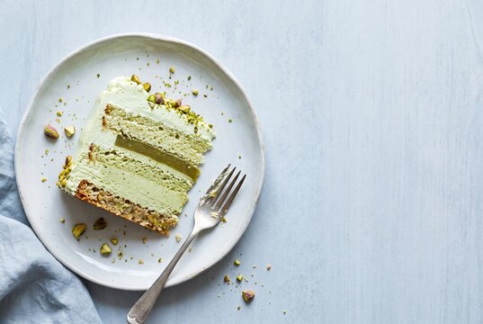 Pistachio cream cake slice on a dessert plate