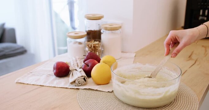 Cooking process. Pastry recipe. Woman chef hand stirring checking thick liquid dough preparing with spoon on wooden kitchen table.