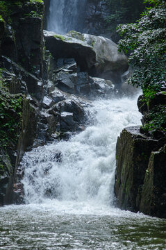 Majestic Mountain Stream with Cascading Water and Rock Formations in Forest Setting