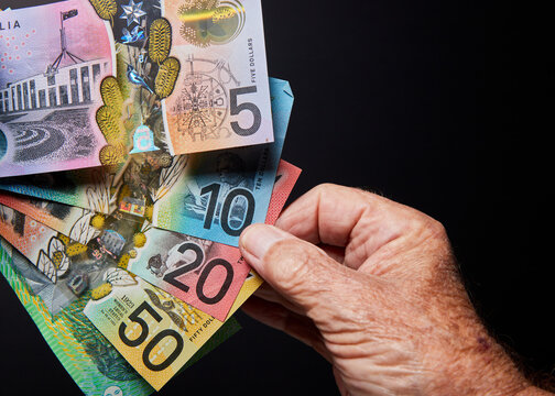 banknotes with hand on black background