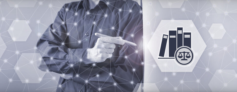 Legal professional pointing at a digital law codes and regulations icon in a conceptual interface representing legal compliance, legislation, and corporate statutory requirements.
