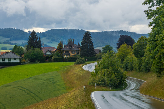 Winding road through a green Swiss village