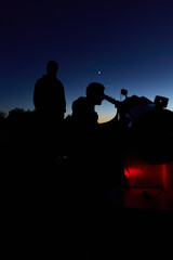 Amateur astronomers observing stars, planets, Moon and other celestial objects with a telescope in nature. © astrosystem