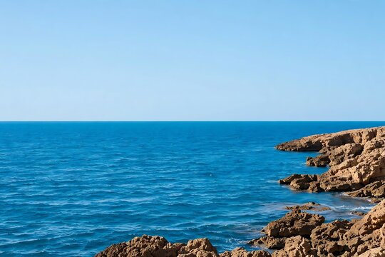 Scenic view of a rocky coastline meeting the deep blue mediterranean sea under a clear sky