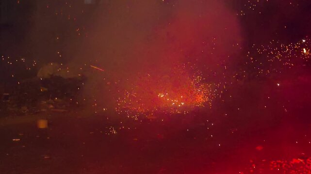 Bright sparks and smoke from ground firecrackers exploding