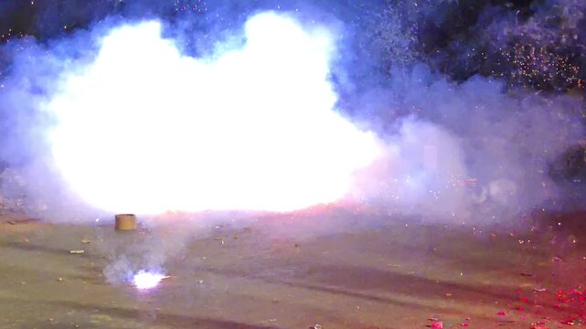 Bright sparks and smoke from ground firecrackers exploding