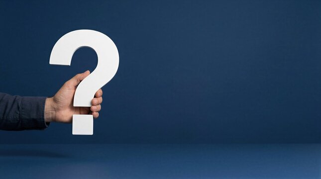 Hand holding white question mark against dark blue background. Unknown question symbol with copy space on right. Curiosity and confusion concept. Decision making and problem solving.
