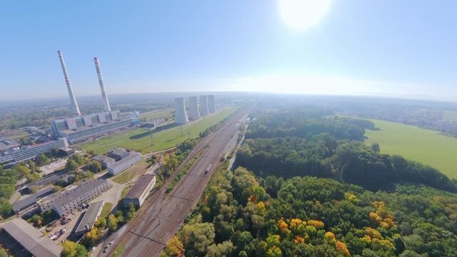FPV drone flies over woodland countryside with views of the tall chimneys of the redundant Detmarovice Coal Power Plant Czech Republic, suitable for industrial heritage, coal energy industry decline