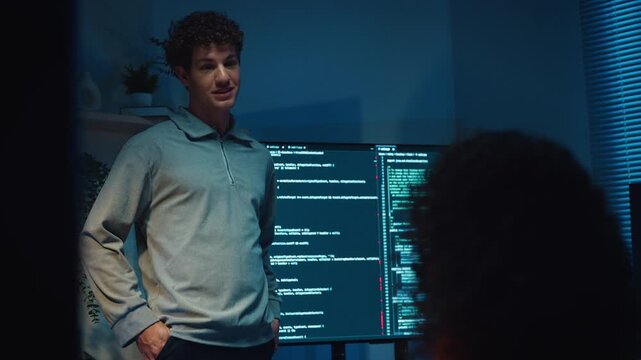Diverse team software developer present coding on screen to colleague at office night. Mentor coach program leader, Creative startup teamwork discuss, Artificial intelligence system workshop concept.