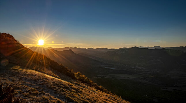 beautiful sunset with seabeam on the sky over range mountain in southern france, europe