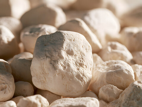 Rough white stones with a large upright pebble in warm light
