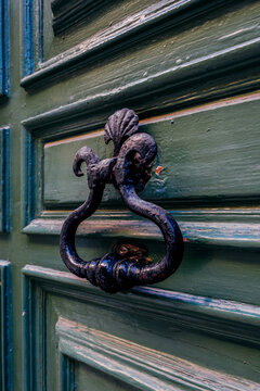 Ornate Black Iron Door Knocker on Dark Green Wooden Panel