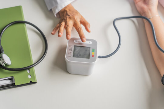  Mature Asian doctor taking the patient's blood pressure