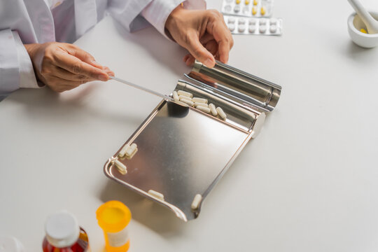  Mature Asian pharmacist using medication tray