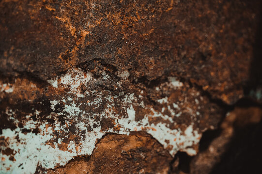 Macro texture shot of heavily corroded reddish-brown rusty metal surface with rough oxidized flaking. Ideal for industrial decay backgrounds, vintage texture overlays, metal corrosion studies, and rus