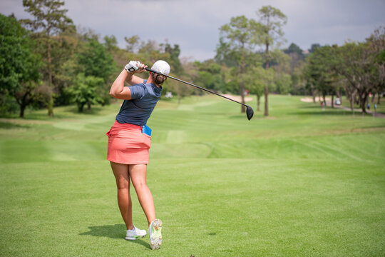 Professional woman golfer teeing golf in golf tournament competition at golf course for winner	