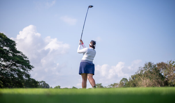 Professional woman golfer teeing golf in golf tournament competition at golf course for winner	