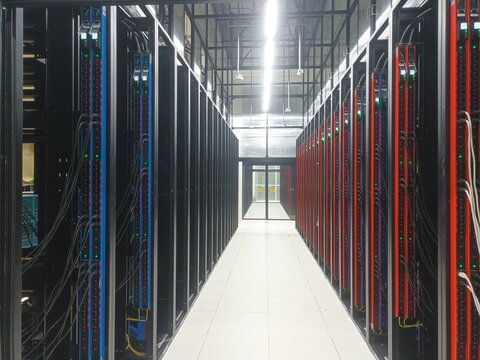 Modern data center server room aisle with PDU racks and exposed underfloor liquid cooling system infrastructure for AI server computing.

Category: