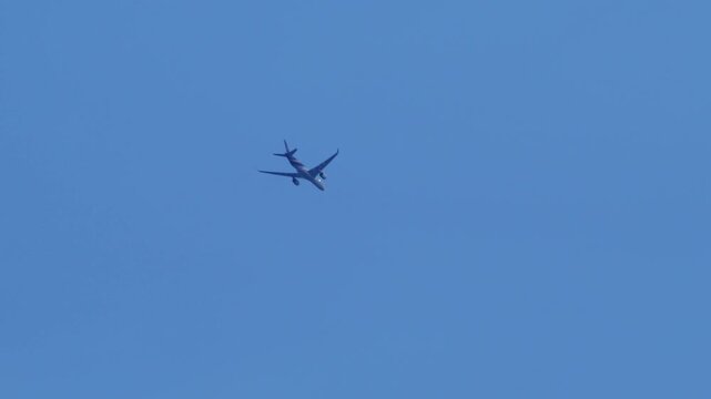 BANGKOK, THAILAND &ndash; OCTOBER 18, 2026: Thai Airways Airbus A350 passenger jet flying overhead in clear blue sky, low angle view, camera panning to follow commercial airplane, air travel concept