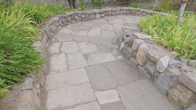 Stone Pathway Winding Through Peaceful Garden With Rustic Rock Wall, Natural Landscaping, Outdoor Walkway, Curved Path, Paving Stone, Green Plant and Lush Foliage for China Travel Photography