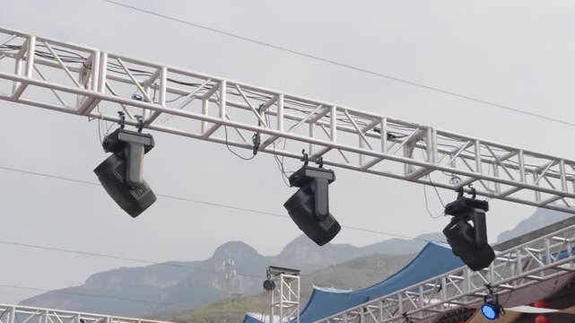 Outdoor Stage Lighting Truss with Mountain Backdrop at Chinese Travel Event, Scenic China Landscape, Blue Canopy, Cloudy Sky, Concert Equipment, and Rocky Mountain Venue