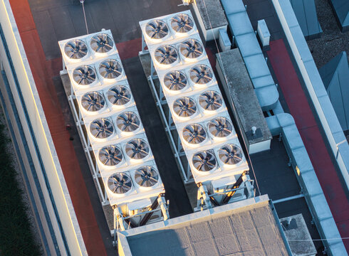 Aerial view of Morasko Campus rooftop featuring industrial HVAC cooling units with multiple fans arranged in rows on a flat roof in Poznan, Greater Poland Voivod, Poland.