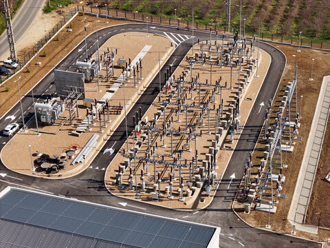 Aerial view of an electrical substation with transformers and switchgear equipment situated on a gravel lot in Serbia.