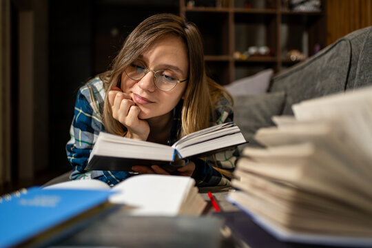 A woman reads a book at night. Studying, tired girl , night and learning for exam, exhausted of research. Bored, college student answers of test, paper and person with bulb for dark