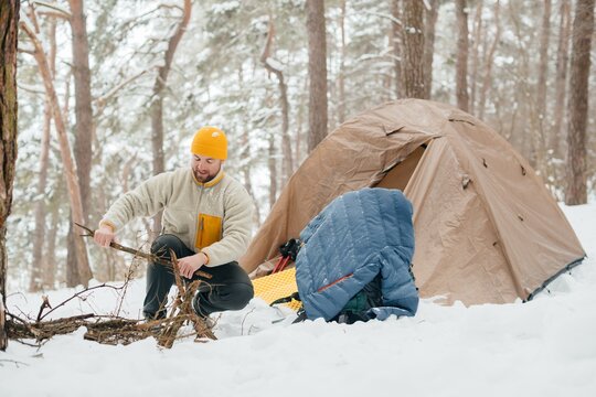 Adventurer preparing firewood for winter camping
