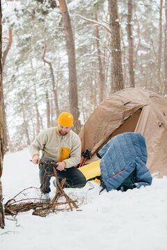 Man preparing firewood for winter solo camping