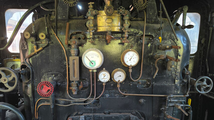 Vintage steam locomotive cab interior with pressure gauges, brass fittings, valves and handwheels © Maroun Rached