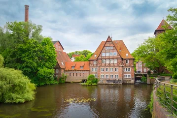 Lüneburg,  Germany - view of Historic Ratsmühle watermill, featuring traditional red brick and half-timbered architecture, orange tiled roofs © bbsferrari